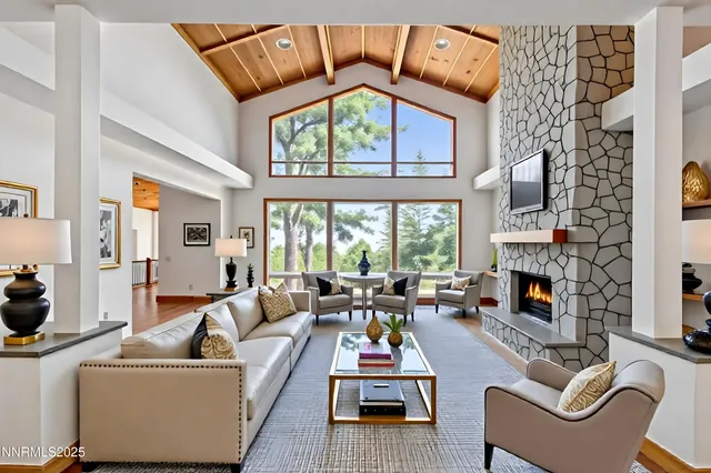 a living room with furniture a fireplace and a large window
