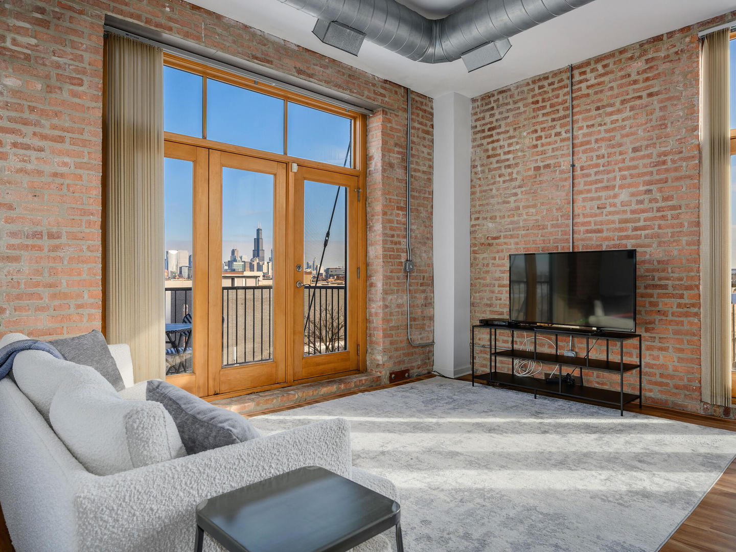 2101 West Rice Street, Unit 408 Chicago, IL 60622 - Photo 5 of 12 a living room with furniture a fireplace and a flat screen tv