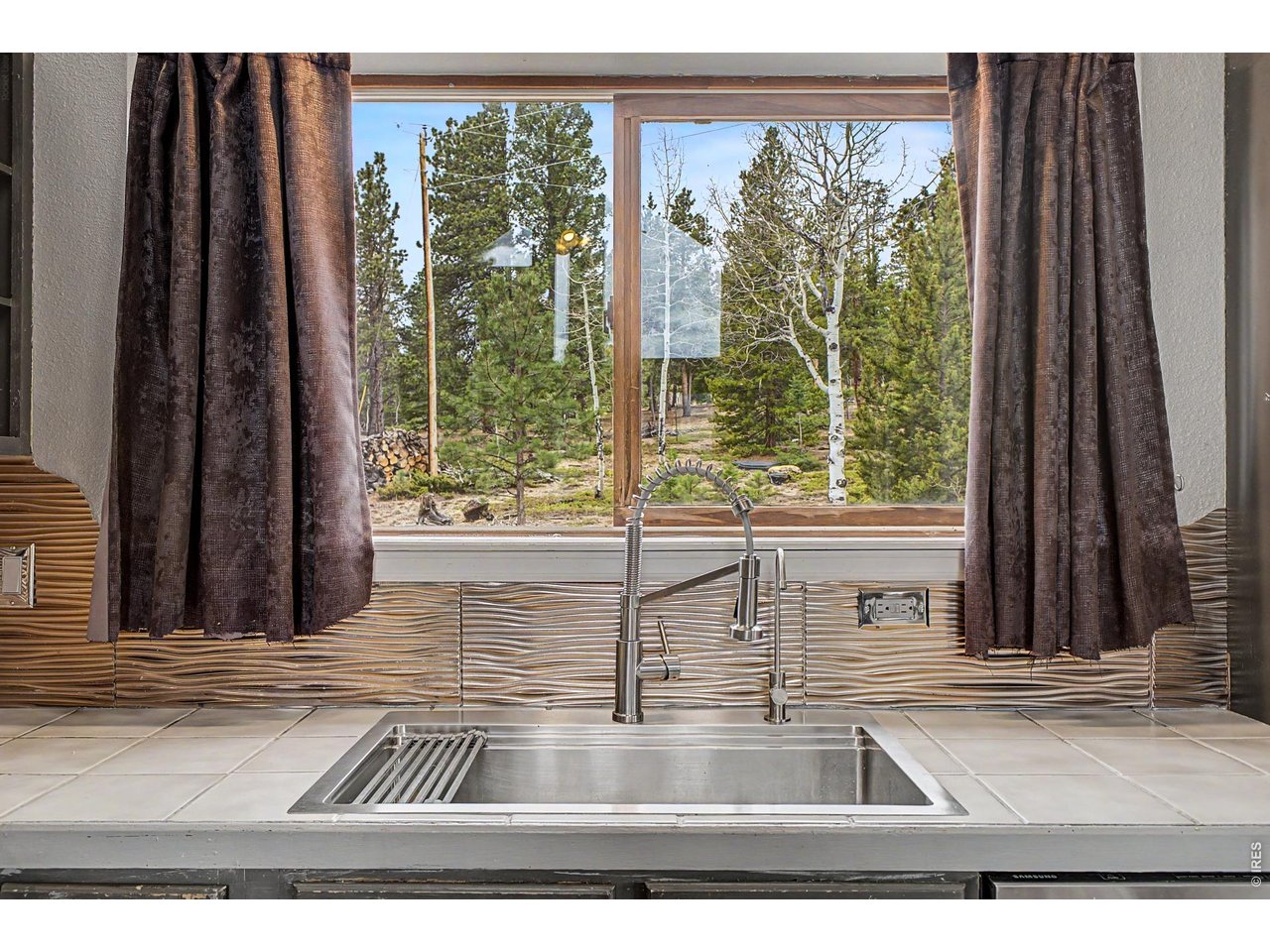 76 Highlands Drive Bailey, CO 80421 - Photo 15 of 49 a view of a living room with a floor to ceiling window and wooden floor
