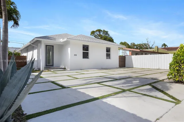a view of a house with a patio and a yard