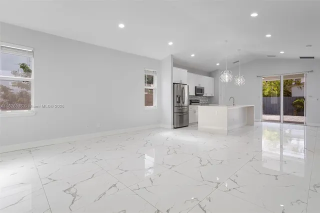 a view of kitchen with refrigerator and windows