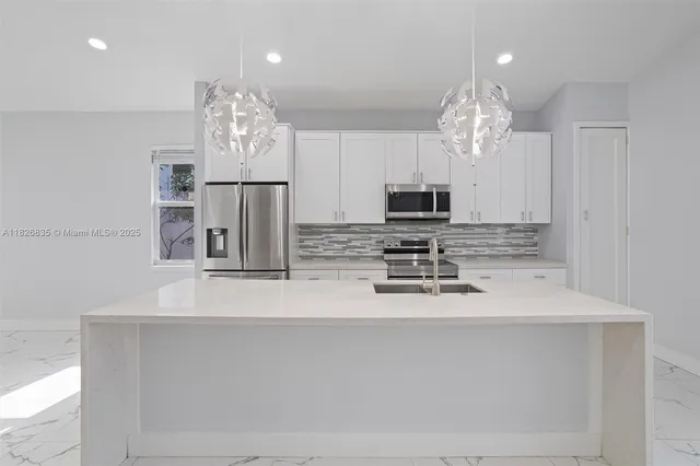 a view of a kitchen with granite countertop a sink dishwasher a refrigerator and a fireplace