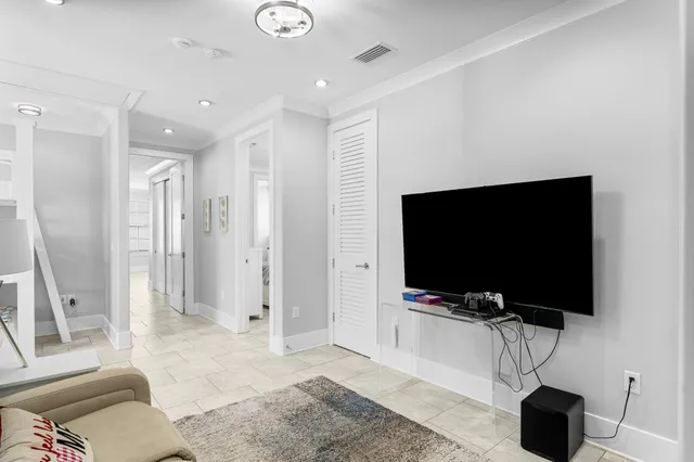 a living room with a flat screen tv and a view of living room
