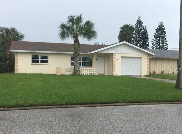 a front view of a house with a garden and yard