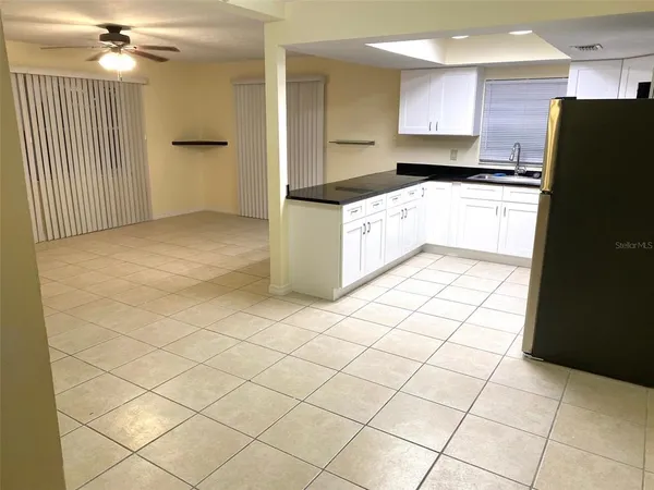 a kitchen with granite countertop a refrigerator and a stove top oven