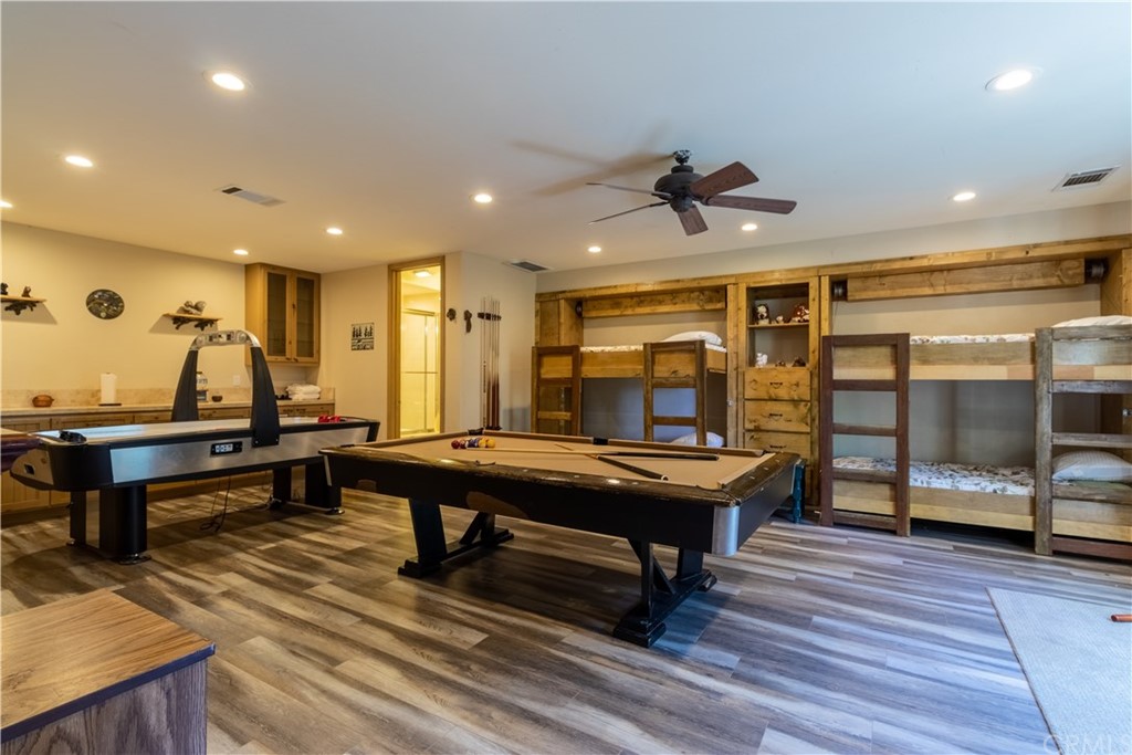 43490 Primrose Drive Big Bear Lake, CA 92315 - Photo 38 of 69 a living room with a table a rug and potted plants with wooden floor