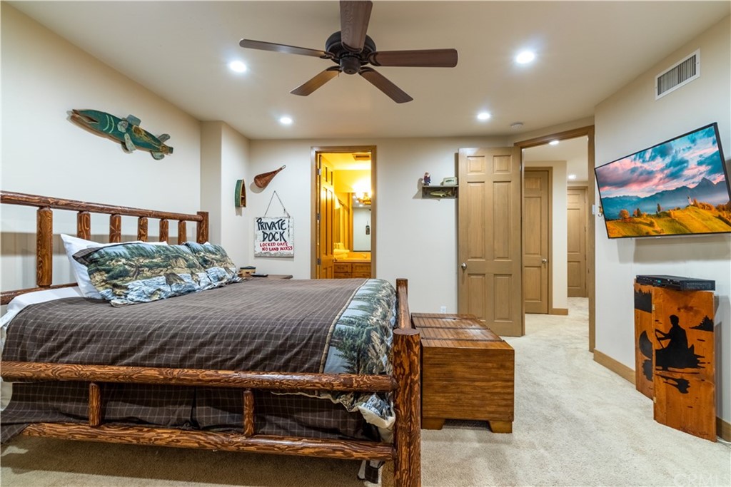 43490 Primrose Drive Big Bear Lake, CA 92315 - Photo 46 of 69 a bedroom with a bed and a chandelier