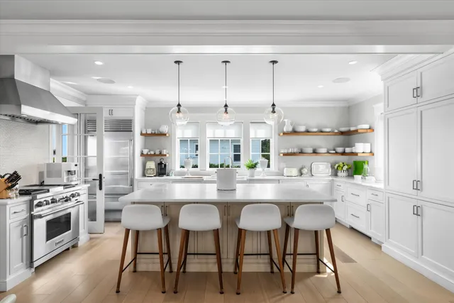 a kitchen with kitchen island granite countertop a sink cabinets and stainless steel appliances