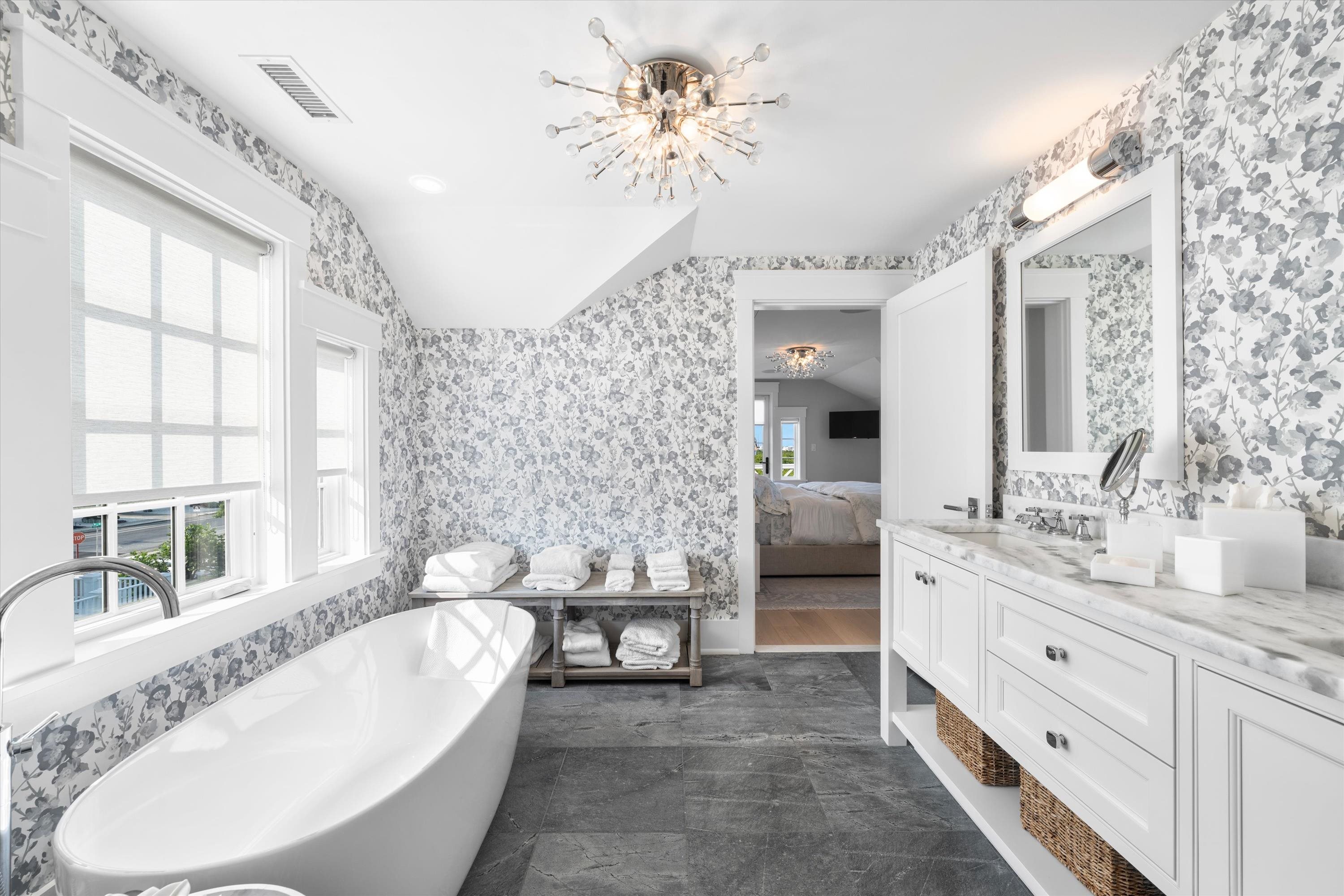 74 38th Street Avalon, NJ 08202 - Photo 39 of 50 a spacious bathroom with a double vanity sink a large mirror a bathtub and a window