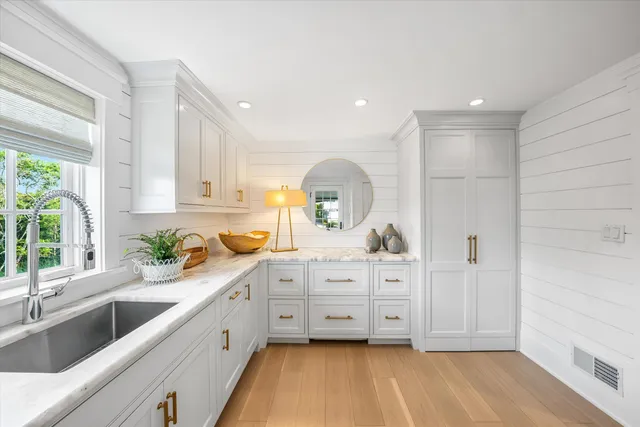 a large white kitchen with a large window