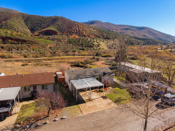 an aerial view of a house with a mountain