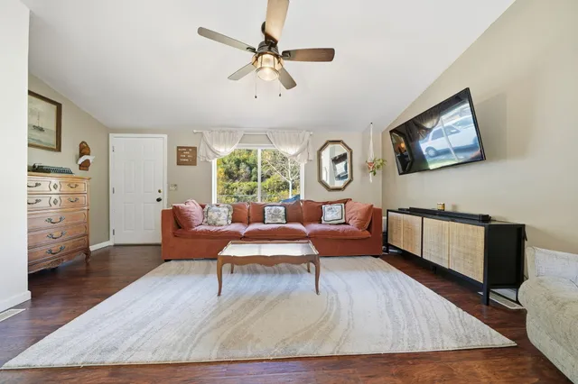 a living room with furniture and a wooden floor