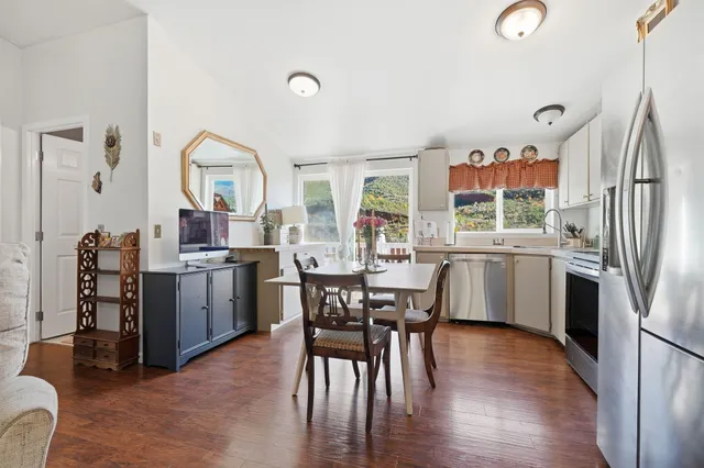 a kitchen with a table chairs refrigerator and microwave