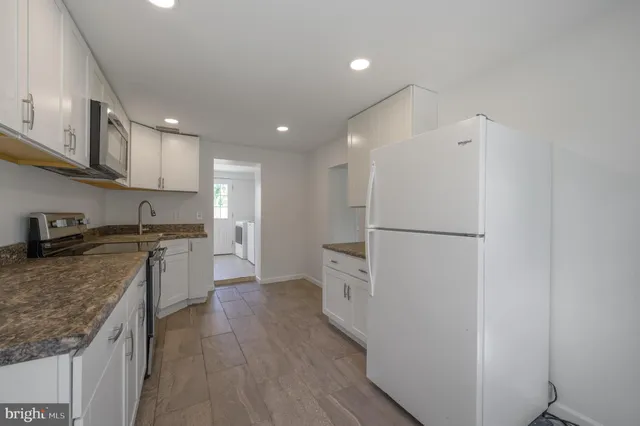 a kitchen with a refrigerator a sink and wooden cabinets