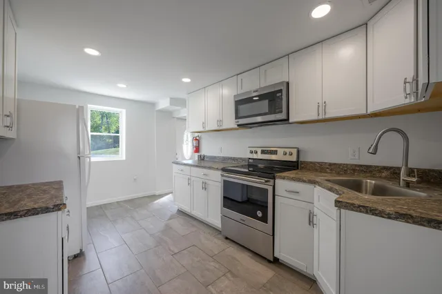 a kitchen that has a sink and a stove top oven