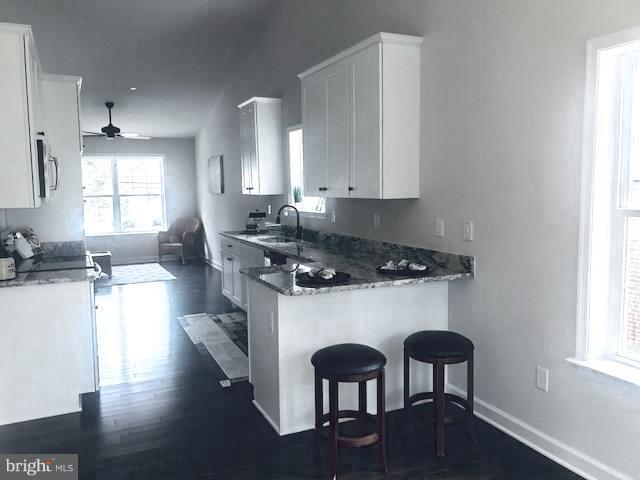 439 West Maple Road Linthicum Heights, MD 21090 - Photo 11 of 30 a kitchen with stainless steel appliances a sink a stove a table and chairs