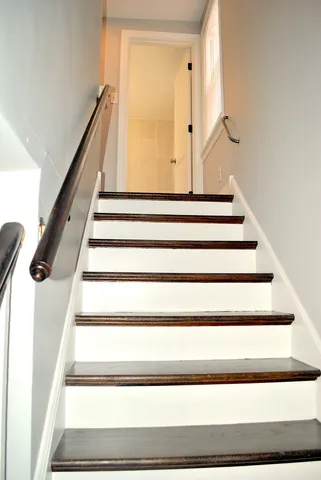 a view of staircase with white walls and a window