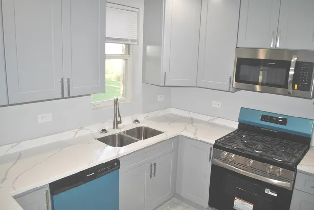 a kitchen with stainless steel appliances granite countertop a sink stove and cabinets