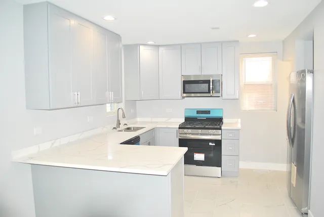 a kitchen with stainless steel appliances granite countertop a stove and a refrigerator