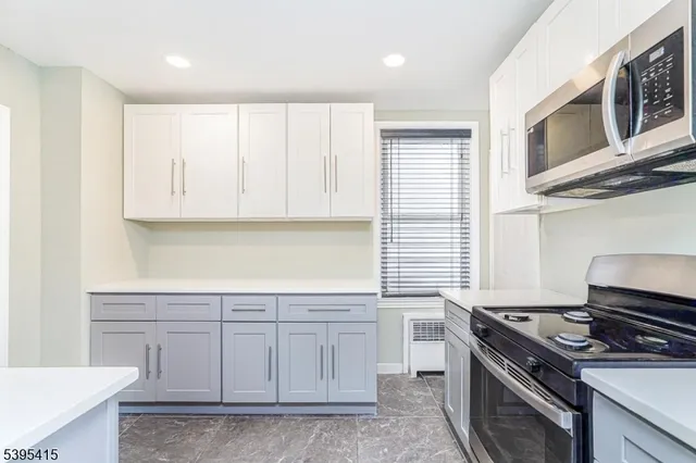 a kitchen with stainless steel appliances granite countertop a stove and a microwave