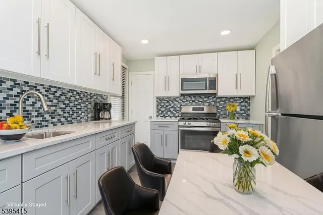 a kitchen with a sink white cabinets and stainless steel appliances