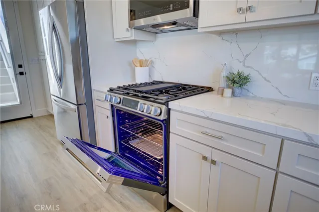 a stove top oven sitting inside of a kitchen