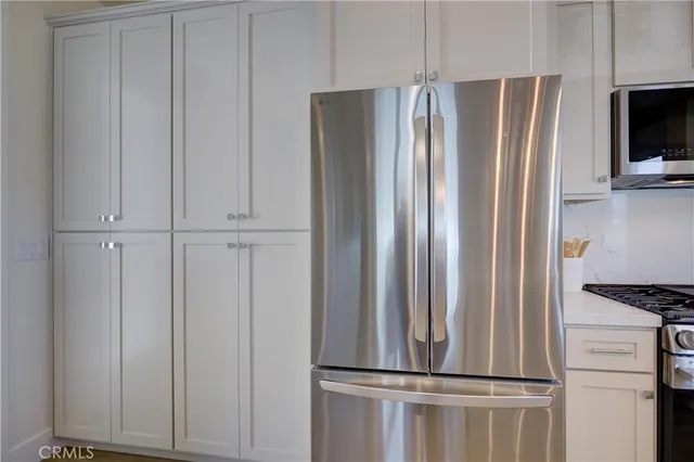 a view of kitchen with refrigerator and cabinet