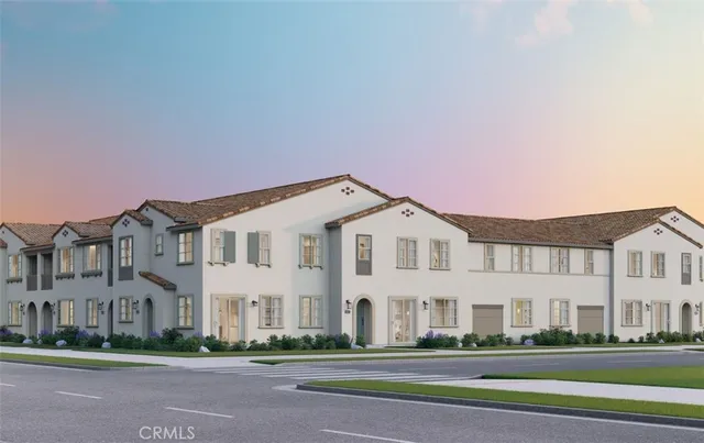 a front view of a white house with a big yard and potted plants