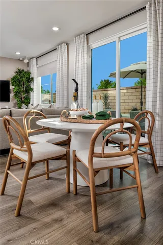 a dining room with furniture window and wooden floor
