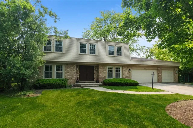 a front view of a house with a garden and yard