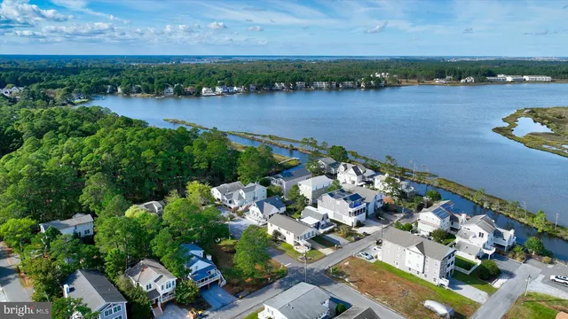 an aerial view of multiple house with outdoor space and lake view