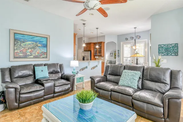 a dining room with furniture a chandelier and wooden floor