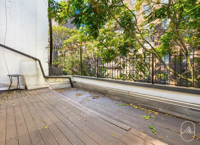 a view of wooden floor and trees in the background
