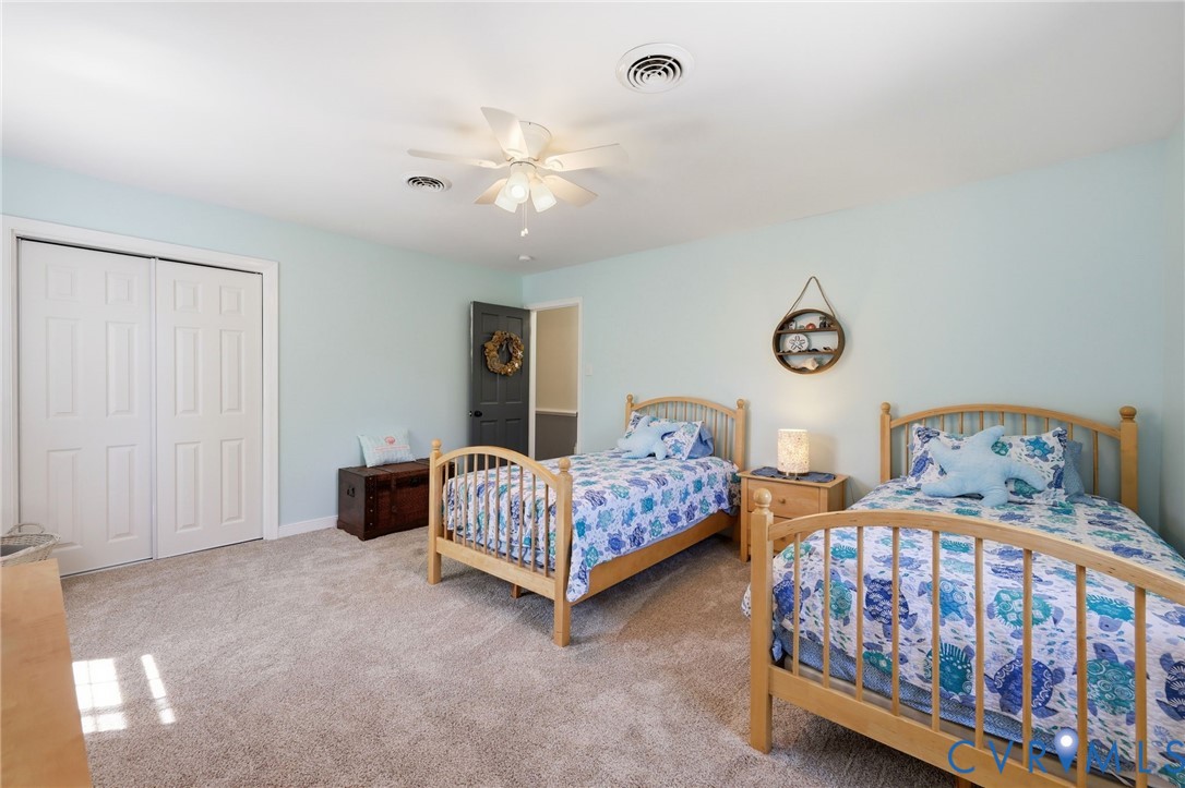 11200 Surry Road Chester, VA 23831 - Photo 31 of 48 a bedroom with two beds and a chandelier