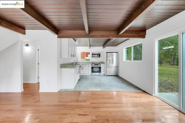 an empty room with wooden floor and a window