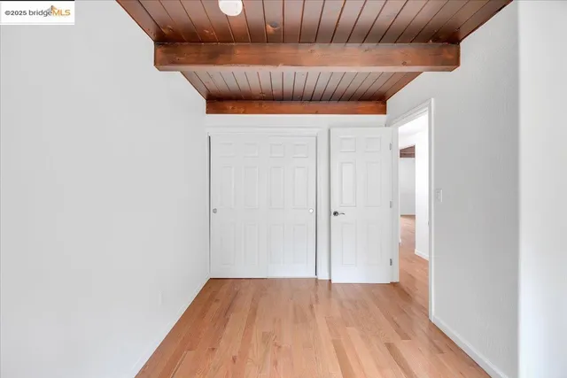 a view of a hallway with wooden floor and a window
