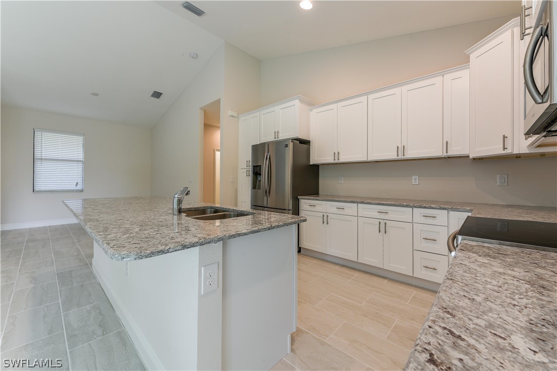 8160 Anhinga Road Fort Myers, FL 33967 - Photo 4 of 25 a kitchen with granite countertop a sink and cabinets
