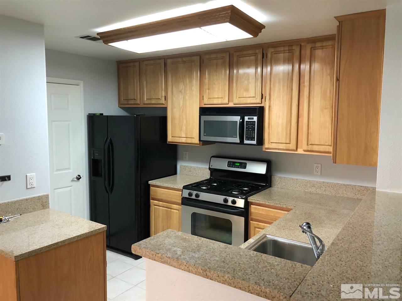 900 South Meadows Parkway, Unit 1712 Reno, NV 89521 - Photo 5 of 13 a kitchen with a refrigerator stove and microwave