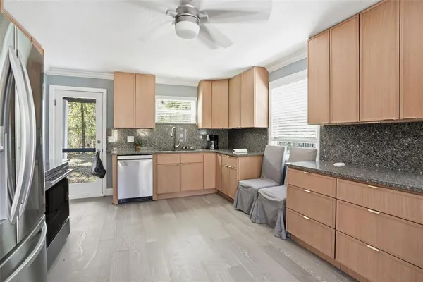 a kitchen with granite countertop a refrigerator and a stove top oven