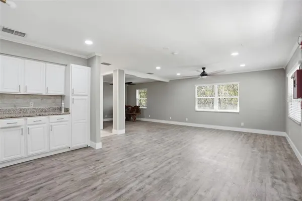 an empty room with a window and a fan