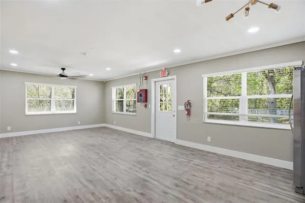 an empty room with a window and a ceiling fan