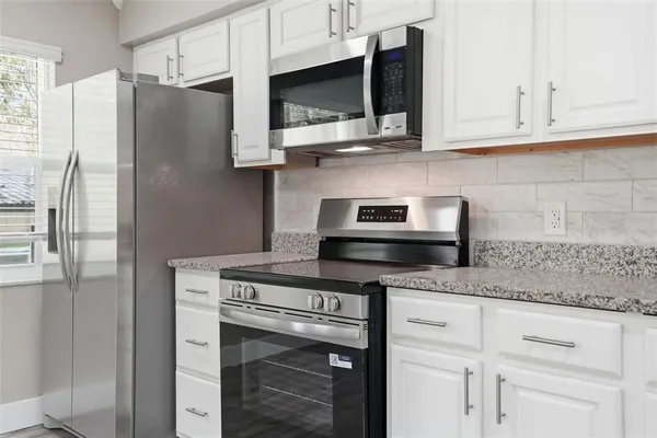 an empty room with a window and a ceiling fan