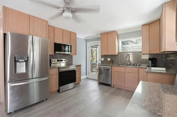 a large kitchen with a lot of counter space and stainless steel appliances