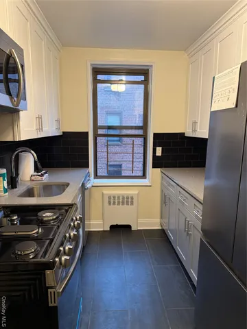 a kitchen with stainless steel appliances a sink stove and cabinets