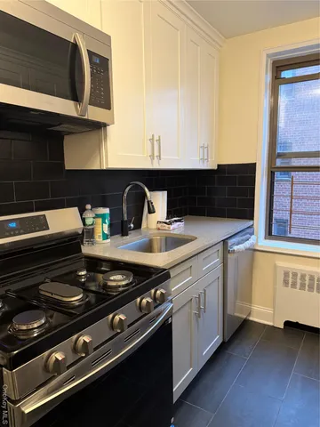 a kitchen with stainless steel appliances a stove and a microwave