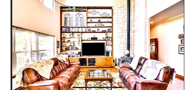 a living room with furniture a flat screen tv and a floor to ceiling window