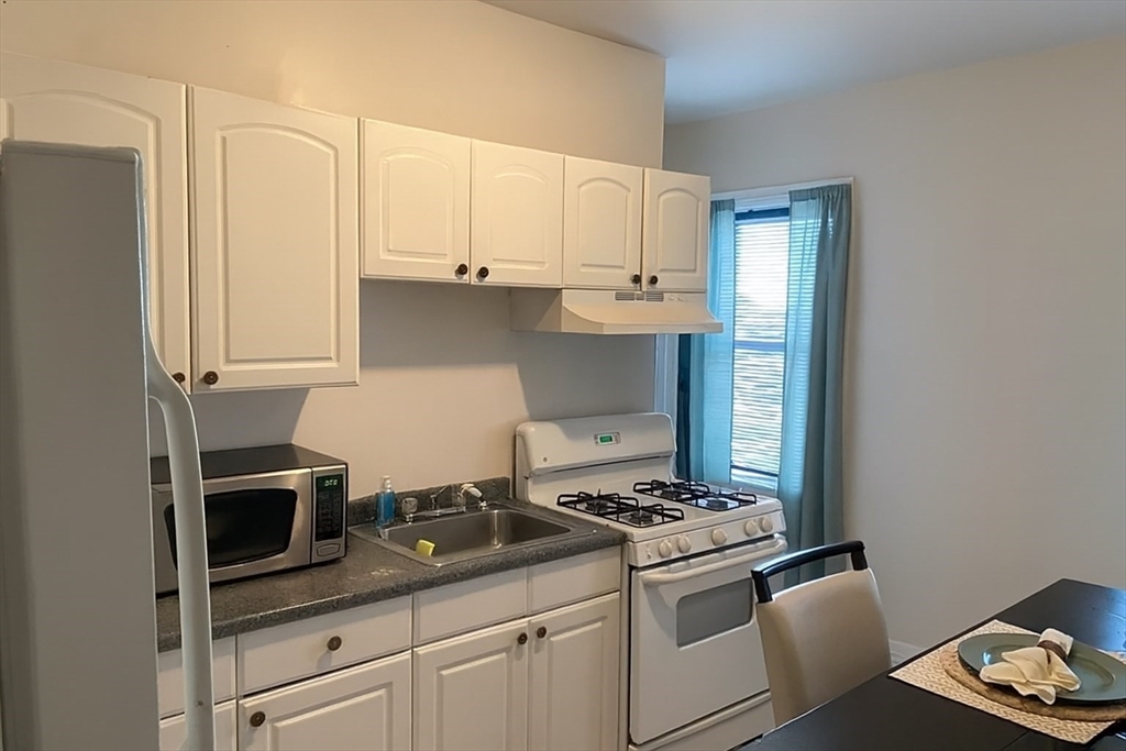 256 Union Street, Unit 3 Fall River, MA 02721 - Photo 1 of 4 a kitchen with stainless steel appliances granite countertop a stove a refrigerator and a microwave