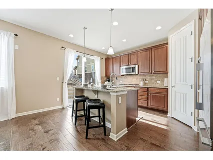 a kitchen with kitchen island granite countertop a sink cabinets and stainless steel appliances