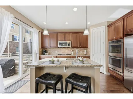 a kitchen with stainless steel appliances granite countertop a refrigerator and a stove top oven