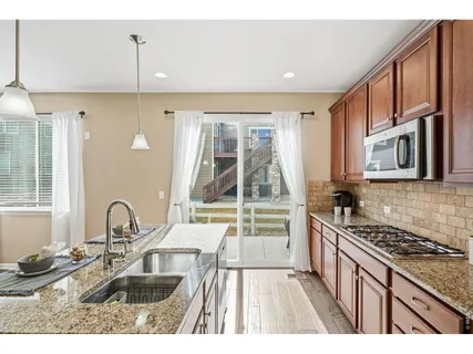 a kitchen with granite countertop a stove a sink and a microwave